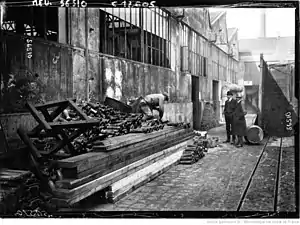 Photographie en noir et blanc d'obus le long d'une usine.