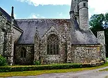 À gauche le pinacle intact, sur un contrefort du croisillon. Puis la petite fenêtre. Puis, au centre, la grande fenêtre sous pignon, encadrée de deux contreforts.