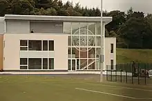 un bâtiment blanc derrière une pelouse