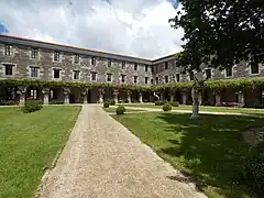 Vue depuis l'allée du jardin sur le couvent orné de sa glycine