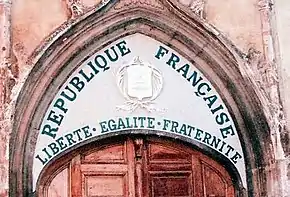 Vue rapprochée d'un tympan d'église recouvert d'écriture.