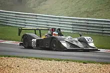 Photographie d'une voiture de sport-prototype noire, vue de trois-quarts avant, sur une piste.