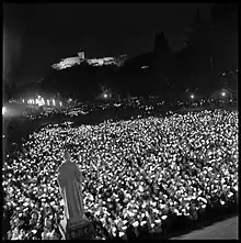  vue de haut d'une procession aux flambeaux à Lourdes, multitude de lumièresdans la nuit.