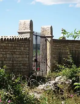 L'ancienne entrée principale du cimetière (piliers gravés d'un alpha et d'un oméga).