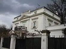 Partie haute de la façade d'une maison ancienne en pierre blanche.