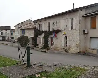 Agence postale et pompe à eau au premier-plan.