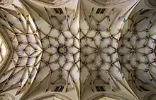 Un plafond blanc avec de nombreuses arcades ramifiées.