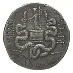 Personnage tenant un bâton et une coupe, debout sur un coffre en osier, encadré de deux serpents.