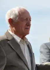 Photo en buste d'un homme âgé en costume gris.