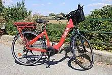 Photographie en couleurs d’un vélo électrique rouge.