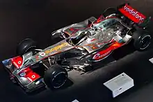 Photo d'une monoplace argentée et rouge en epxosition