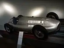 Photo d'une monoplace exposée dans un musée sur un plan incliné.