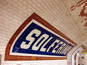 Carreaux en faïence de style Nord-Sud indiquant le nom de la station.