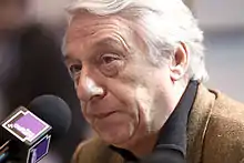 Photographie d'un homme s'exprimant dans un micro.