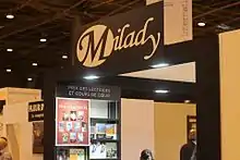 Photographie en couleurs d'une partie de hall d'exposition, montrant principalement une enseigne et plusieurs livres exposés