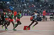 Photographie de Mo Farah menant le peloton durant la finale du 5 000 m