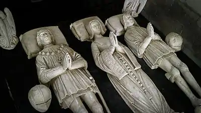 Vue plongeante sur les trois gisants en albâtre d'un tombeau.