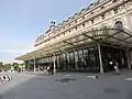 Façade d'un grand bâtiment parisien doté d'un vaste préau couvert.
