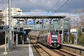 Cliché en couleur. Visualisation de deux quai. Une rame automotrice se trouve à l'un d'eux.
