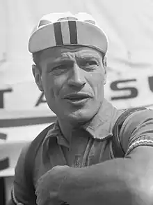 Portrait en noir et blanc d'un homme qui porte une casquette et un maillot de cycliste.