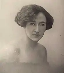 portrait photographique en noir et blanc d'une jeune femme brune semblant fixer le spectateur