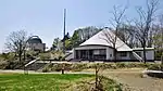 Photo couleur montrant une station d'observation astronomique avec un bâtiment (planétarium) au premier plan.