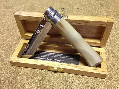 Un couteau ouvert à moitié dans un boite en bois