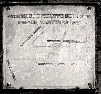 Plaque historique avec le tracé (effacé) de la porte.