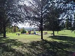 L'aire de jeux du parc Saint-Hubert, avec en fond une vue sur la vallée de la Bourbre.