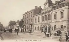 Reproduction d'une carte postale en noir et blanc présentant une vue de trois-quarts de la façade de la mairie
