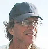 Un homme d'une soixantaine d'années portant une casquette.