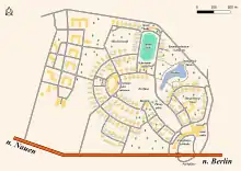 Carte à encre noire sur fond vert représentant une sorte de pentagone. Au centre, un grand parc ; le Sud a une route bordée d'arbres. Les bâtiments sont presque tous identiques et longent des rues incurvées. Un étang est à l'Est, ainsi que des forêts dans la partie Sud du village olympique. Une grande arche marque l'entrée du village au Nord. Au Nord-Est, on voit une piste d'athlétisme.