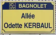 Photo d'une plaque de rue portant la mention « Allée Odette Kerbaul » sur fond jaune.