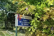 Photographie en couleur d'une plaque de rue.