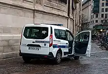 Vue de trois-quarts arrière droit d'une fourgonnette blanche à vue panoramique, stationnant.