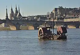 L'obélisque du pont tel qu'aligné avec les flèches de l'église Saint-Nicolas, et les arches avec les aubes d'une toue cabanée.