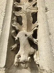 Sculpture d'un petit chien descendant d'une feuille de vigne.