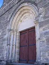 Portail principal de l'église, en arc brisé et à chapiteaux ornés de motifs végétaux