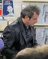 Photographie d'un homme consultant un livre.