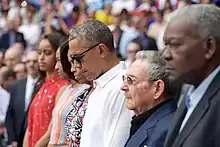 Barack et Michelle Obama, leurs deux filles et Raul Castro observant une minute de silence la tête baissée.