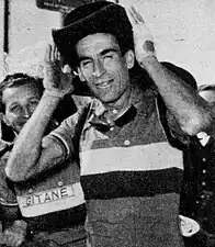 Photo en noir et blanc d'un homme en tenue de cycliste portant un large chapeau noir sur la tête