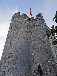 Photographie en couleurs d'une tour cylindrique accolée à une autre carrée.
