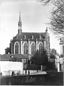 Chapelle des Missionnaires avec la grille et une dépendance de l’hôtel au premier-plan