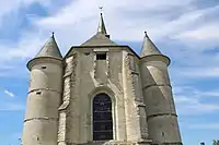 Le chevet en pierre calcaire date du XVIe siècle. Il est flanqué de deux tours percées de meurtrières.