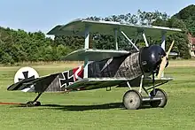 Photo couleur d'un avion triplan au sol.
