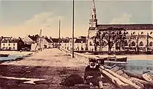 Le pont de Riantec sur l'estuaire du Riant donnant accès à la presqu'île de Kerner et l'église paroissiale Sainte-Radegonde vers 1930 (carte postale colorisée).