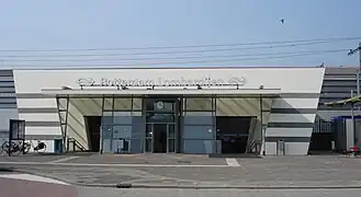 bâtiment de gare précédé par une esplanade piétonne, avec un vélo