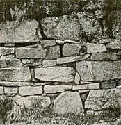 Photographie en noir et blanc des vestiges d'un mur d'une église