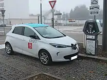 Photographie en couleurs d’une voiture électrique blanche en cours de charge.