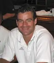 portrait en buste d'un homme en chemise blanche souriant